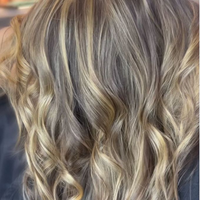 Beige-blonde balayage seen from behind, waved loosely through the lengths.