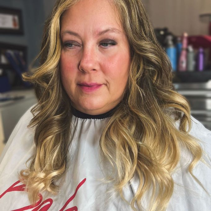 Long blonde extensions blended into the natural lengths and set in loose curls.