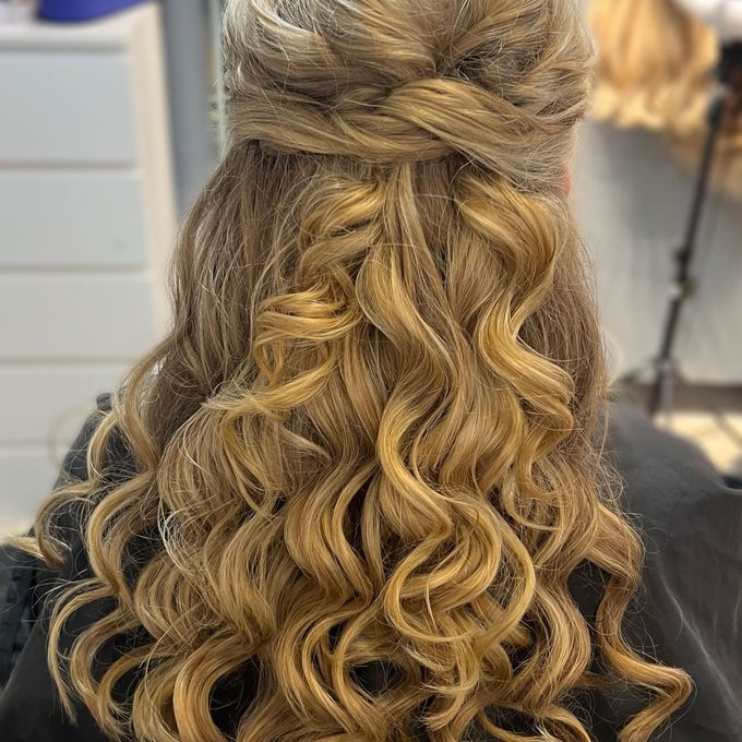 A half-up style with the crown twisted back and pinned and the lengths set in ringlets.